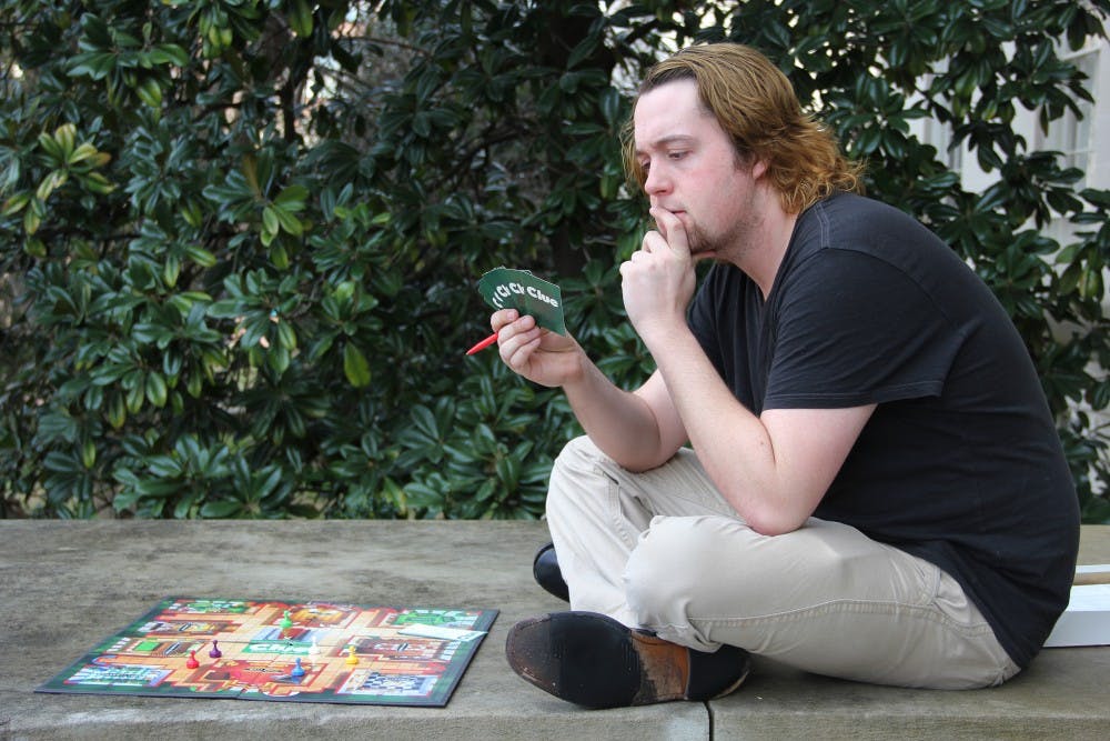 Alex Thompson, director of Cluesicle, poses with a game of Clue that coincides with his play. 