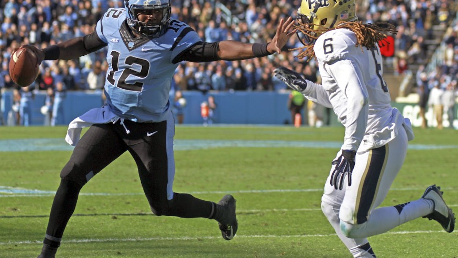 Marquise Williams (12) stiff arms a Pittsburgh defender.