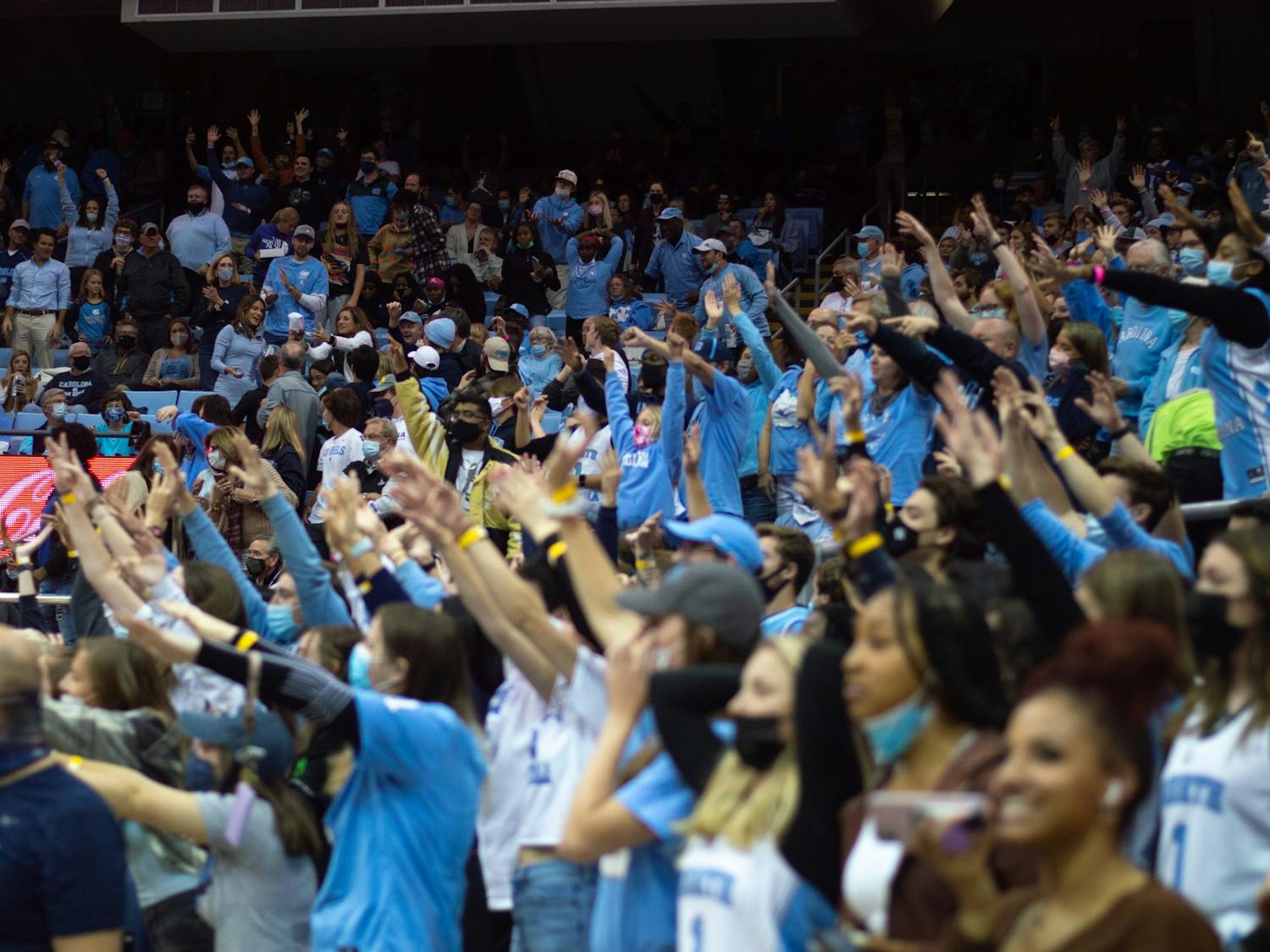 Fans raise their arms during the t-shirt toss at the UNC men's baksetball exhbition game against Elizabeth City State on Nov. 5 2021 at the Dean E. Smith Center in Chapel Hill.