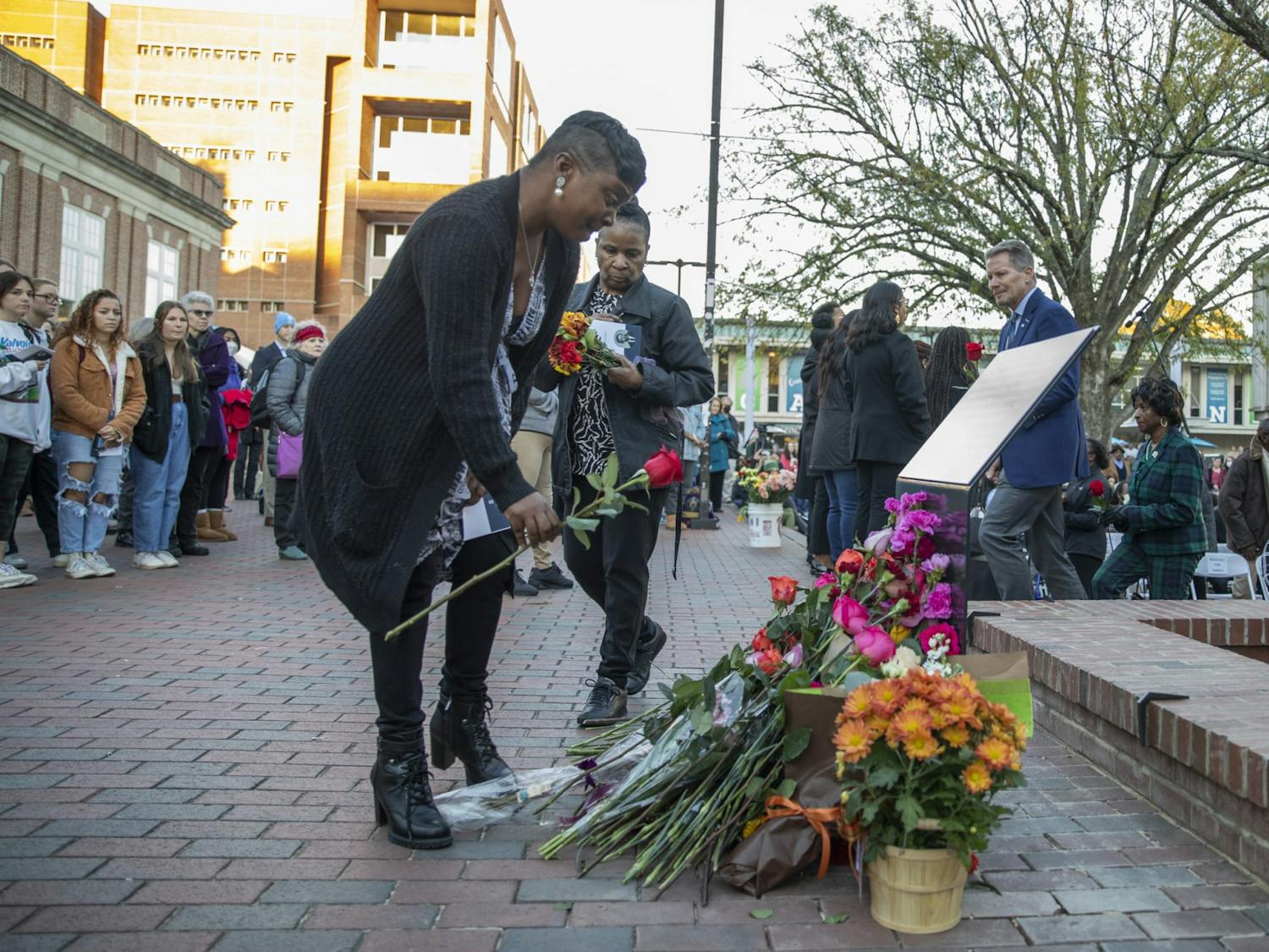 Family members lay flowers at the memorial for James Lewis Cates, Jr. after its dedication on Monday, Nov. 21, 2022.