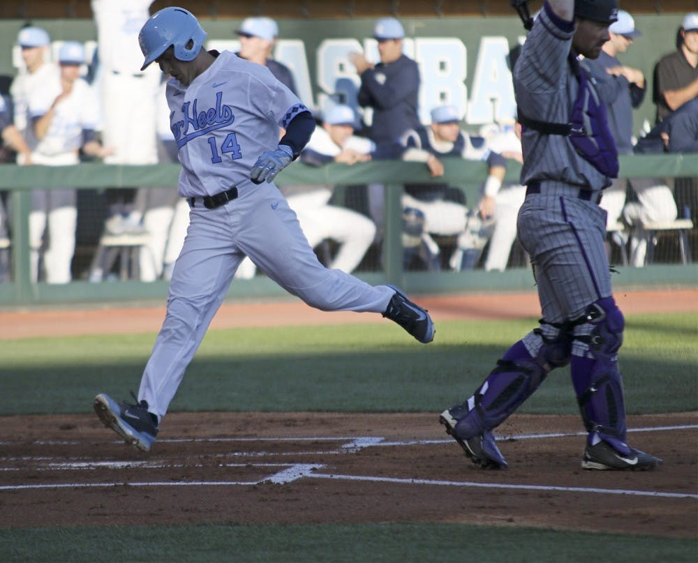 Outfielder Tyler Ramirez (14) scores a run after hitting a triple only minutes before in the first inning against High Point on Tuesday.&nbsp;