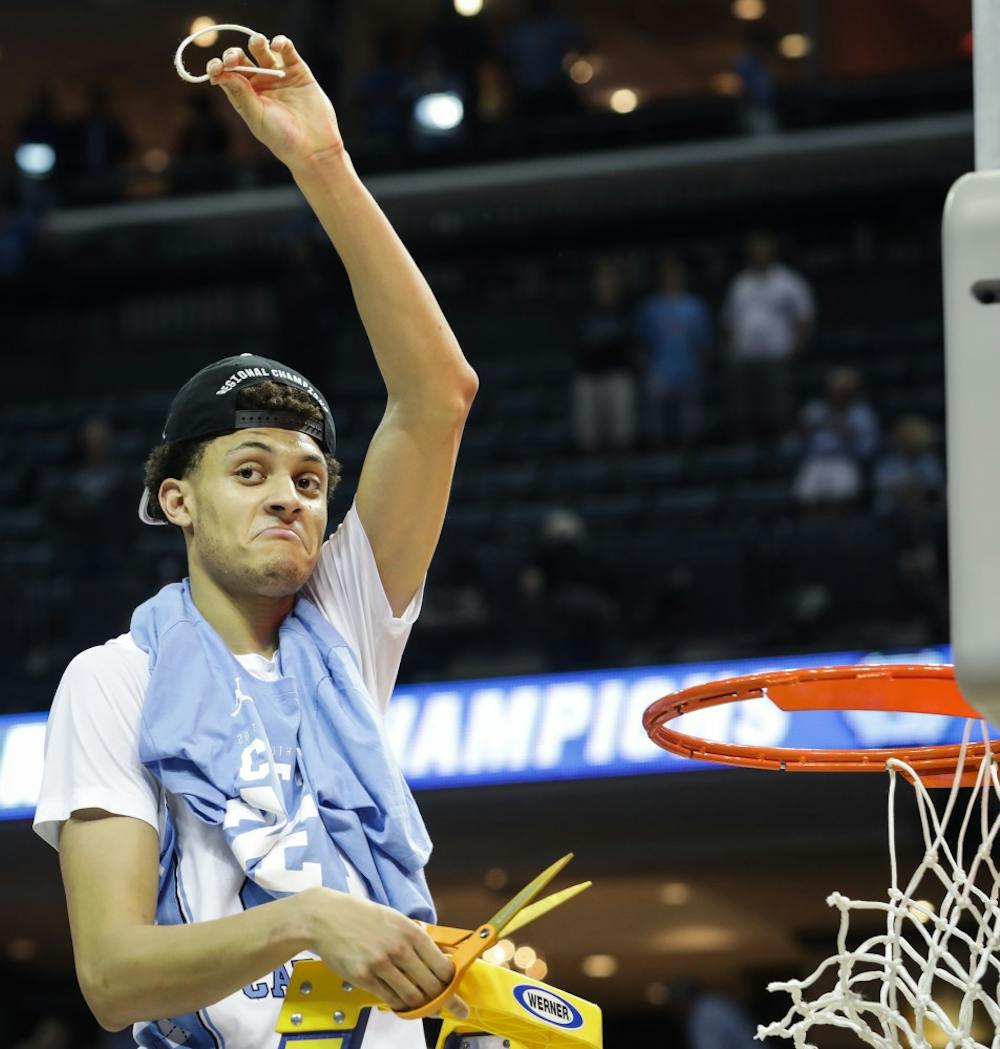 North Carolina wing Justin Jackson (44) holds up a piece of the net after UNC's win over Kentucky in the NCAA Elite Eight game in Memphis on Sunday.