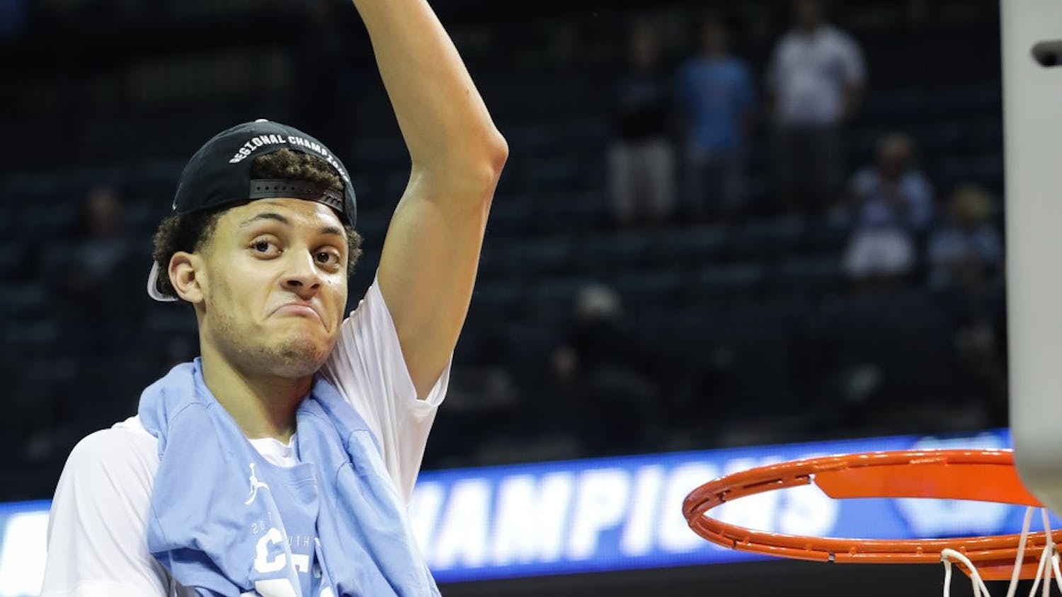 North Carolina wing Justin Jackson (44) holds up a piece of the net after UNC's win over Kentucky in the NCAA Elite Eight game in Memphis on Sunday.