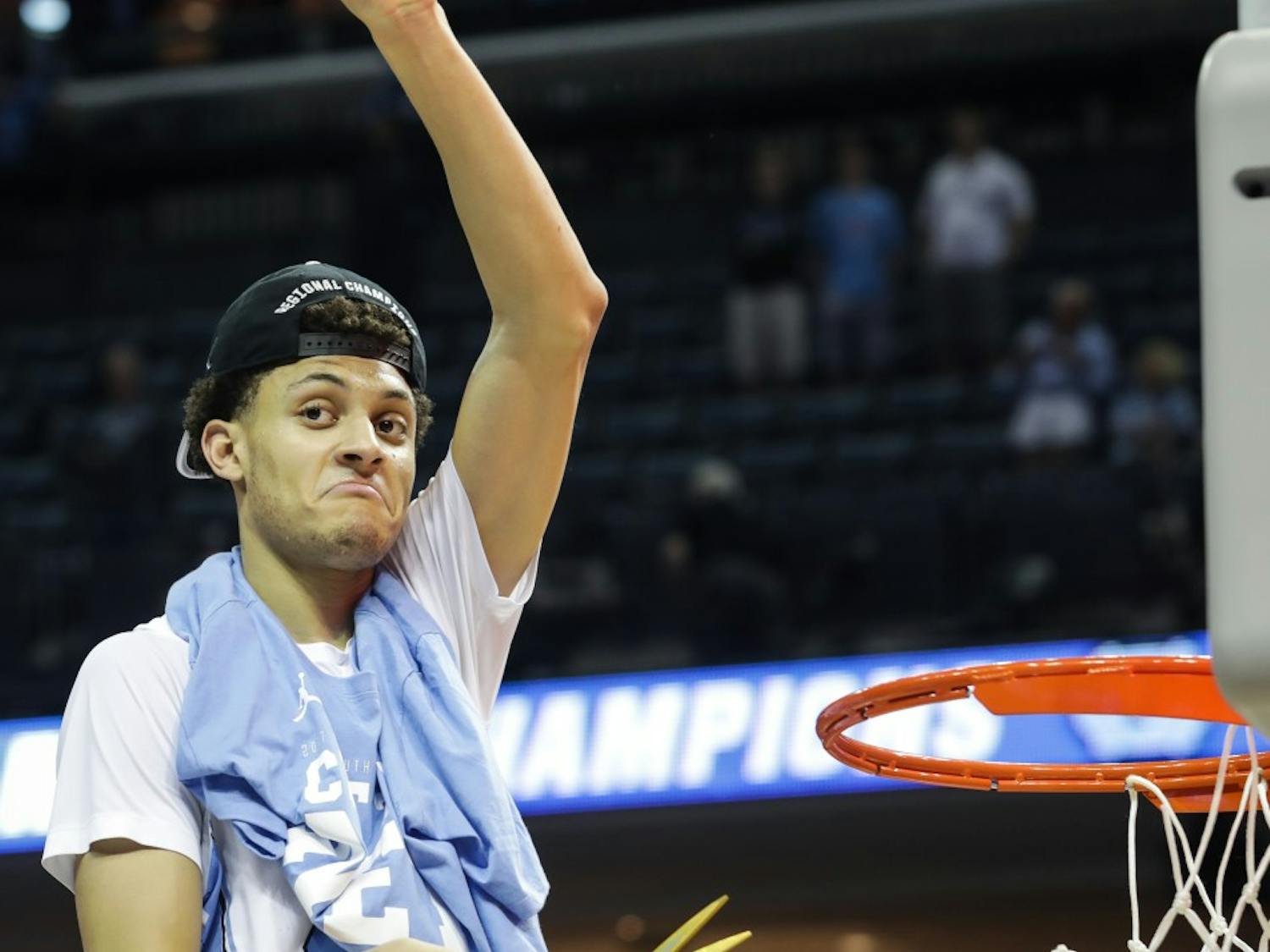 North Carolina wing Justin Jackson (44) holds up a piece of the net after UNC's win over Kentucky in the NCAA Elite Eight game in Memphis on Sunday.