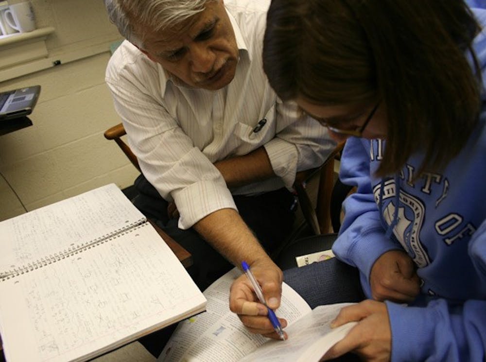 Physics professor Nalin Parikh works with junior Kerry Townsend during his office hours. DTH/Alyssa Champion