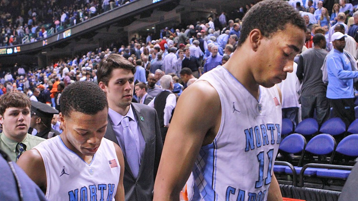 Brice Johnson and Nate Britt hang their heads as they exit the court after UNC lost to Pittsburgh 80-75 in the ACC Tournament at the Greensboro Coliseum.