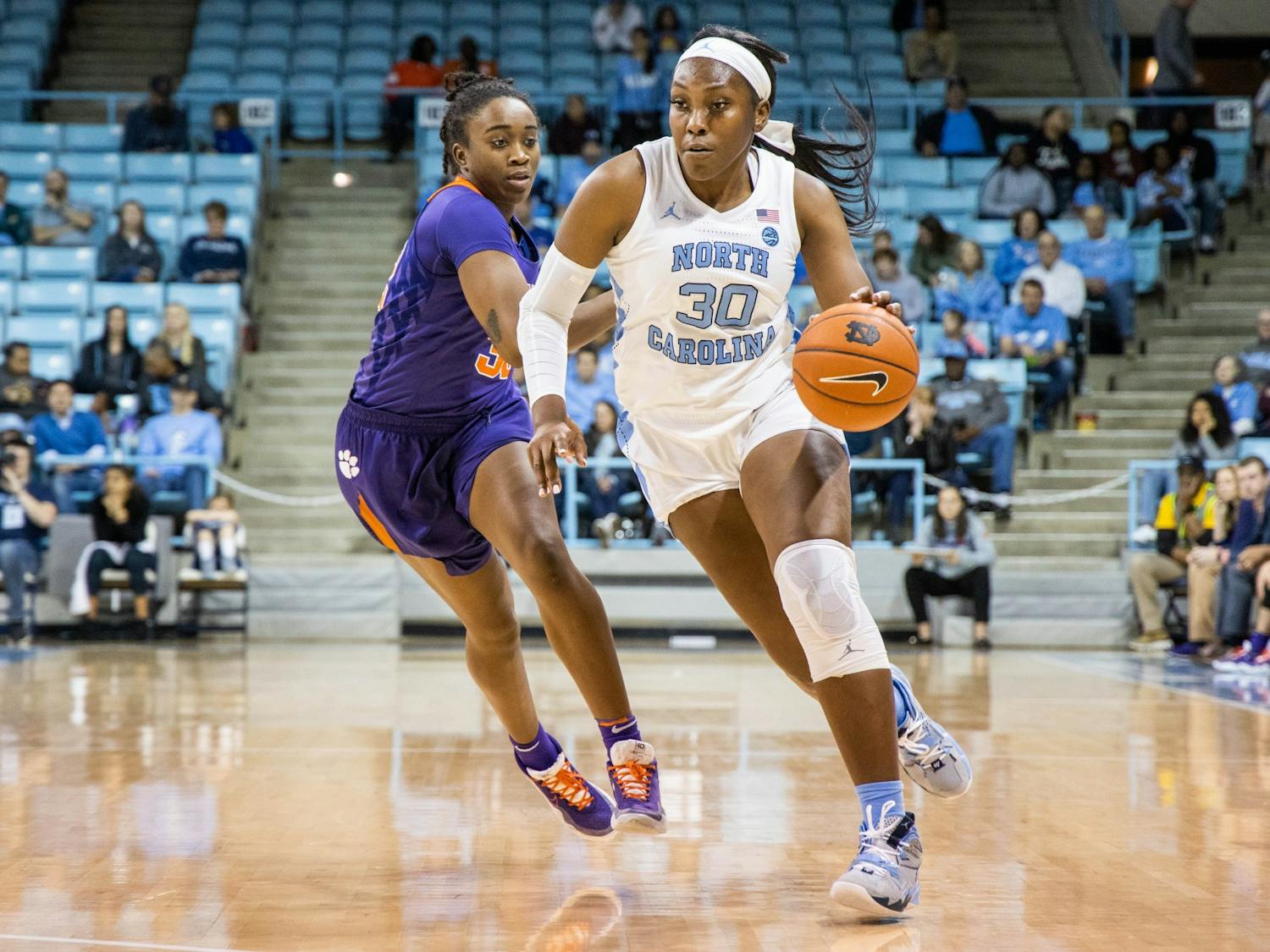 UNC junior center Janelle Bailey (30) dribbles past Clemson University senior guard Chyna Cotton (32). The Tar Heels beat the Tigers 86-72 on Sunday, Feb. 2, 2020 in Carmichael Arena.