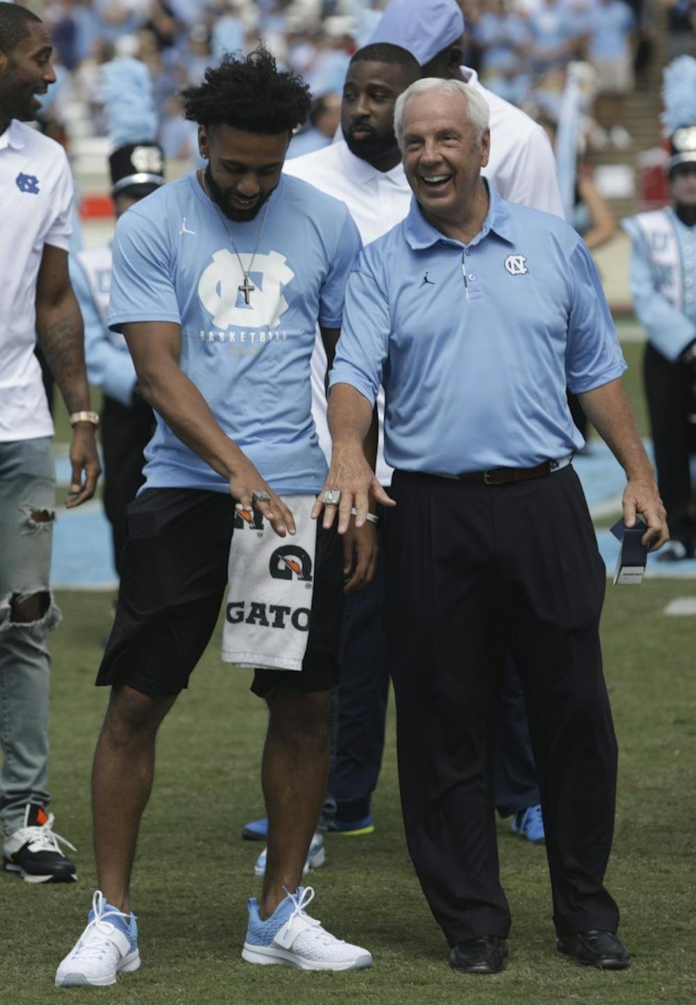 UNC senior point guard Joel Berry II (left) and UNC basketball head coach Roy Williams (right) show off their 2017 NCAA Men's Basketball championship rings during halftime of UNC's game against Louisville Saturday afternoon.&nbsp;