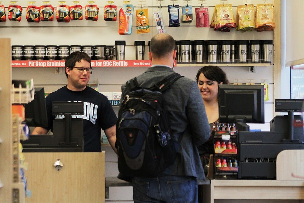 David Deans, from Rocky Mount, N.C. (left) and Katie Coletta (right), senior at English program, from Cary, N.C. are helping Michael Knight, a Ph.D candidate at the Department of Religious Studies check out snacks he buys Tuesday at the Pit Stop.