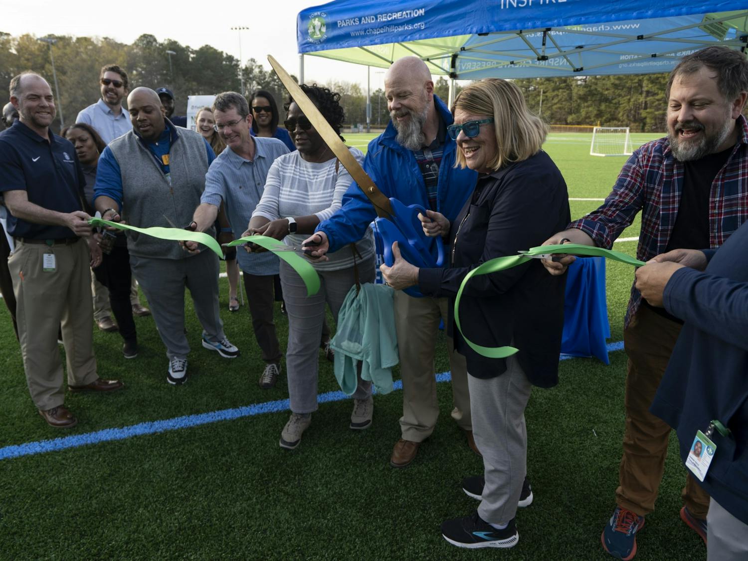 Chapel Hill Town Mayor Pam Hemminger and other representatives cut the ribbon at the ceremony on Thursday, Mar. 23, 2023, to celebrate Cedar Falls Park’s freshly-redone, environmentally-friendly turf for the multi-purpose field.