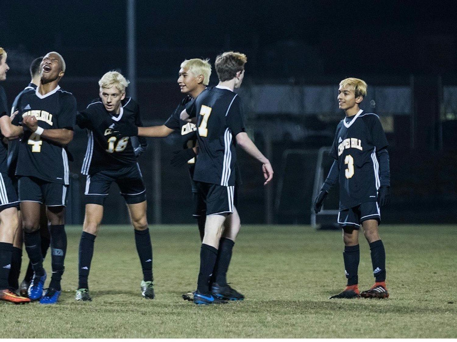 Members of the Chapel Hill High School boy's soccer team celebrate during a game. Photo courtesy of Bryant Davis Jr.