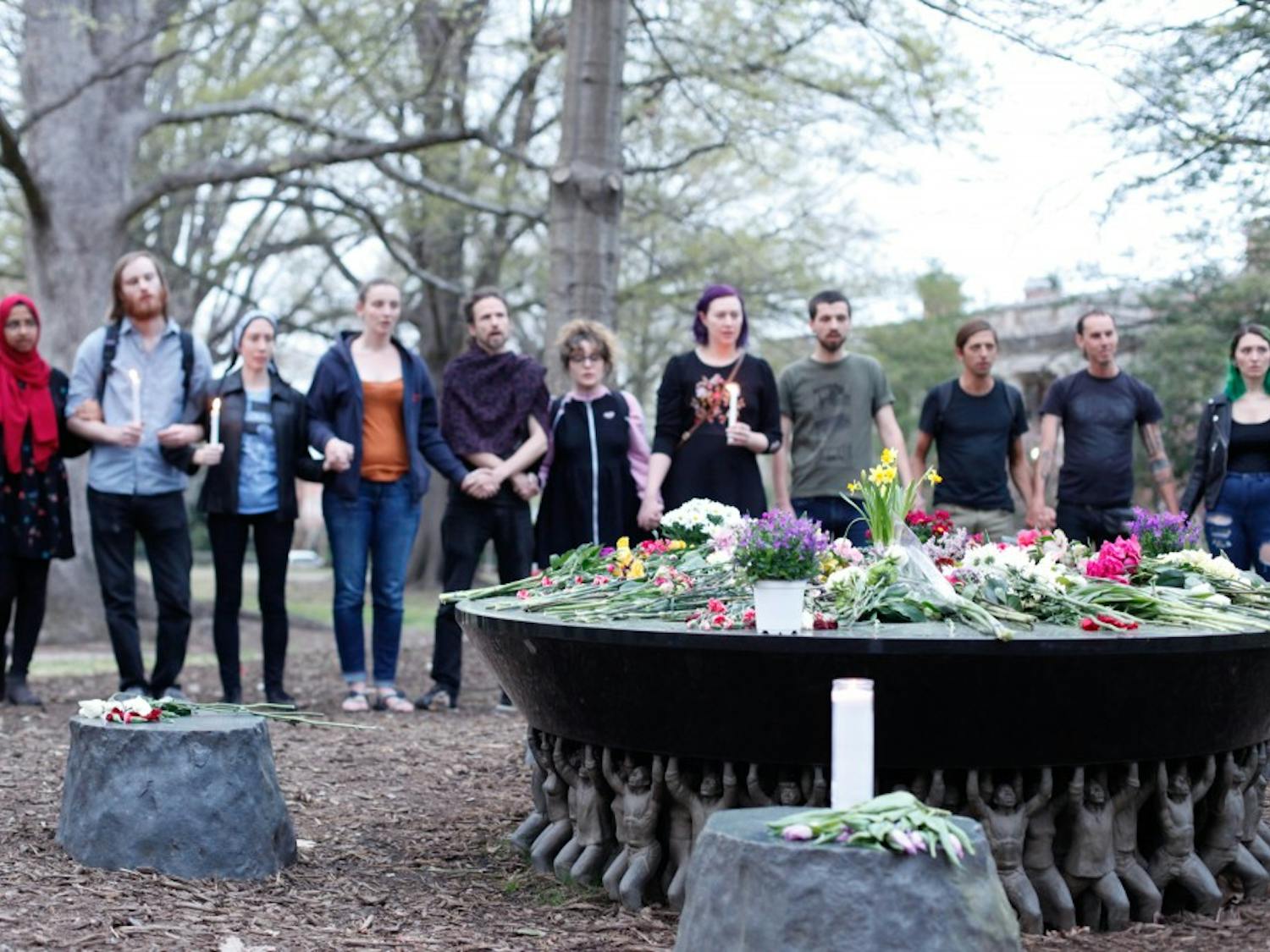 Students and community members hold hands during the Unsung Founders Memorial vigil hosted by UNC Black Congress, Thursday April 4, 2019 at McCorkle Place.