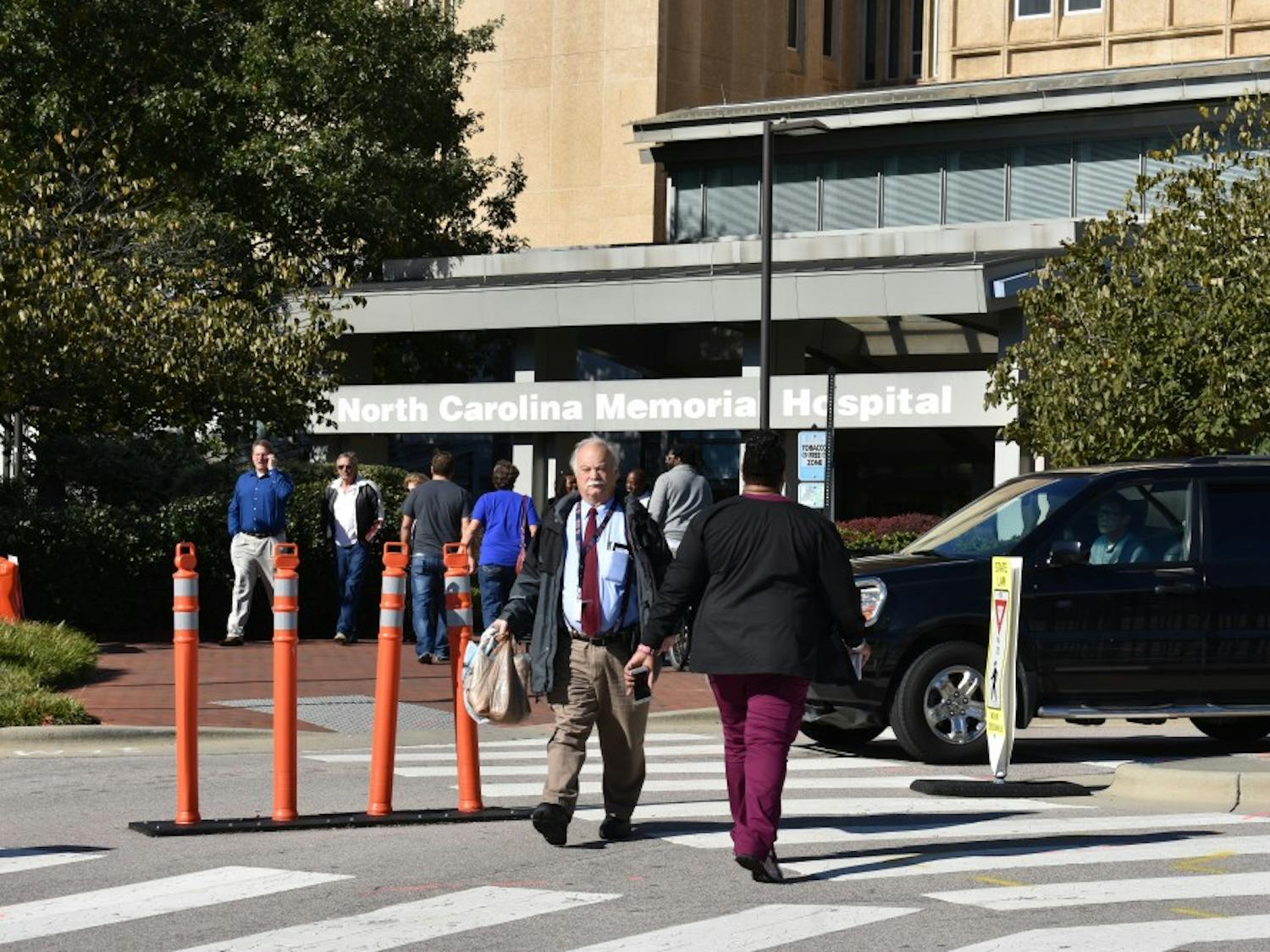 Groups of people enter and exit the N.C. Memorial Hospital, one of several UNC Hospitals.