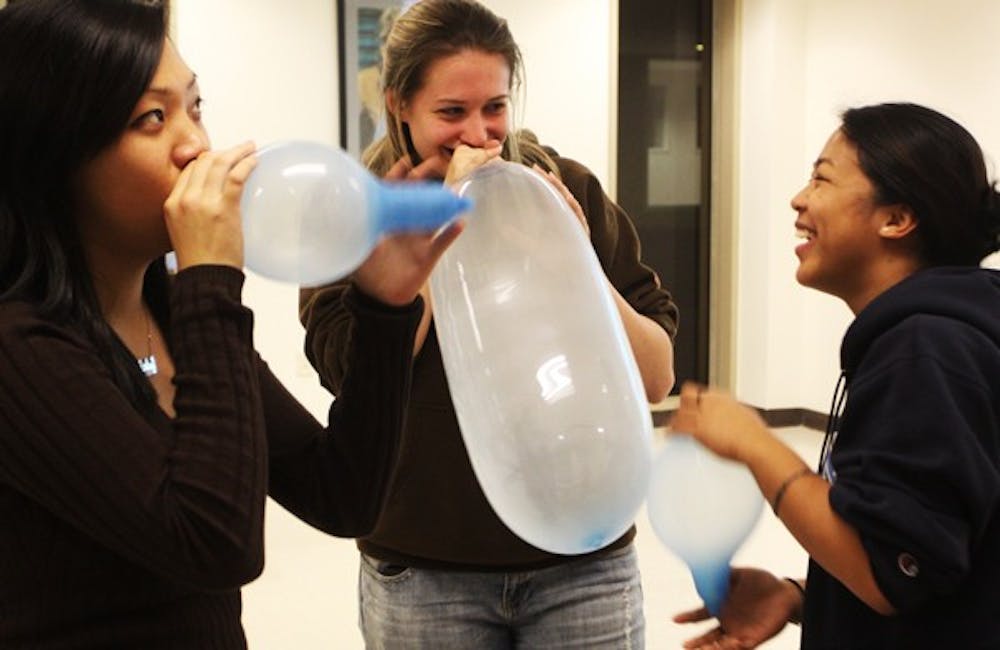 Shirley Lui,  Brittany Miller and  Rachel Quinto compete to blow up the largest condom balloon. DTH/Margaret Cheatham Williams