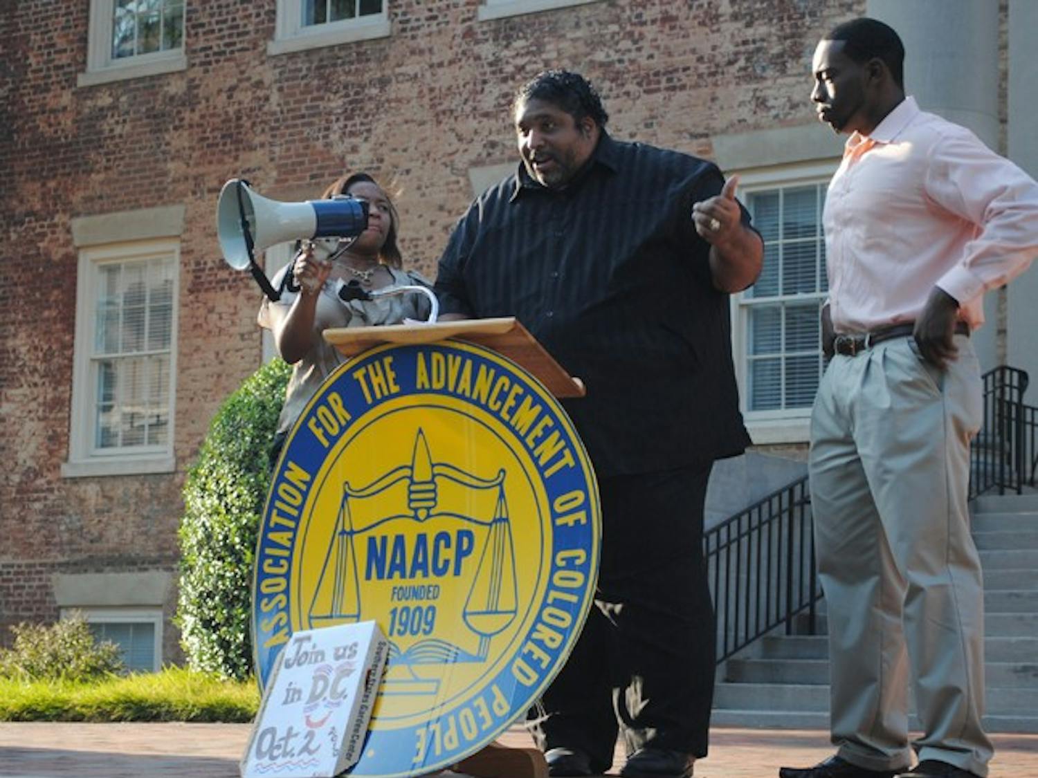 North Carolina NAACP President Rev. William Barber speaks to NAACP supporters outside of South Building on Tuesday evening.