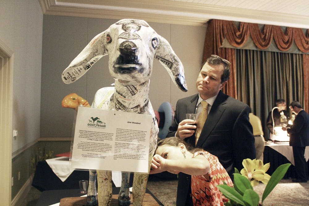The Goat Parade Auction was held at the Galloway Ridge Retirement Community on Friday, Nov. 14. The goats were showcased around the community and then auctioned off to raise money for the senior center. Greg and Tyler Rhinehardt  admire  "Vincent van Goat" was painted by Jane Woodard. "Every time you look at it you see something different." -Greg 