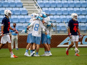 Members of the UNC men's lacrosse celebrate a goal during an 18-16 loss to UVA at Dorrance Field on April 10, 2021.