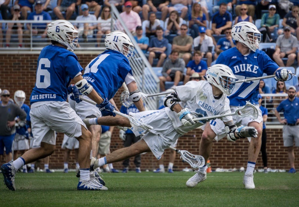 UNC junior midfielder William Perry (3) falls down after making a pass upfield Saturday, March 30, 2019 in their game against Duke.  The Tar Heels won 10-8 at the UNC Lacrosse Stadium.