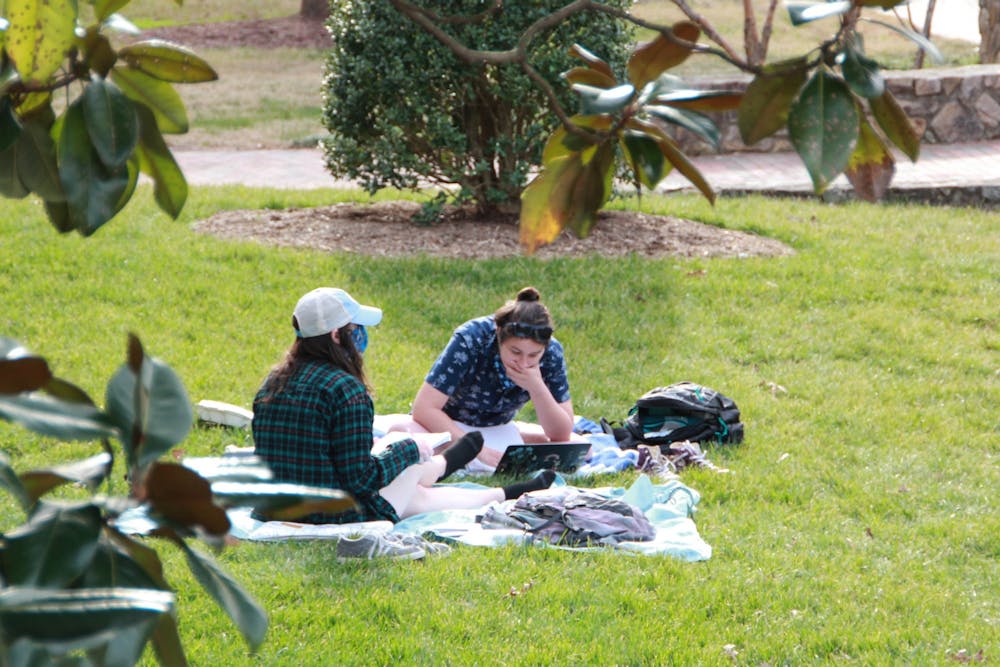 Two students study on the quad on March 9, 2021.