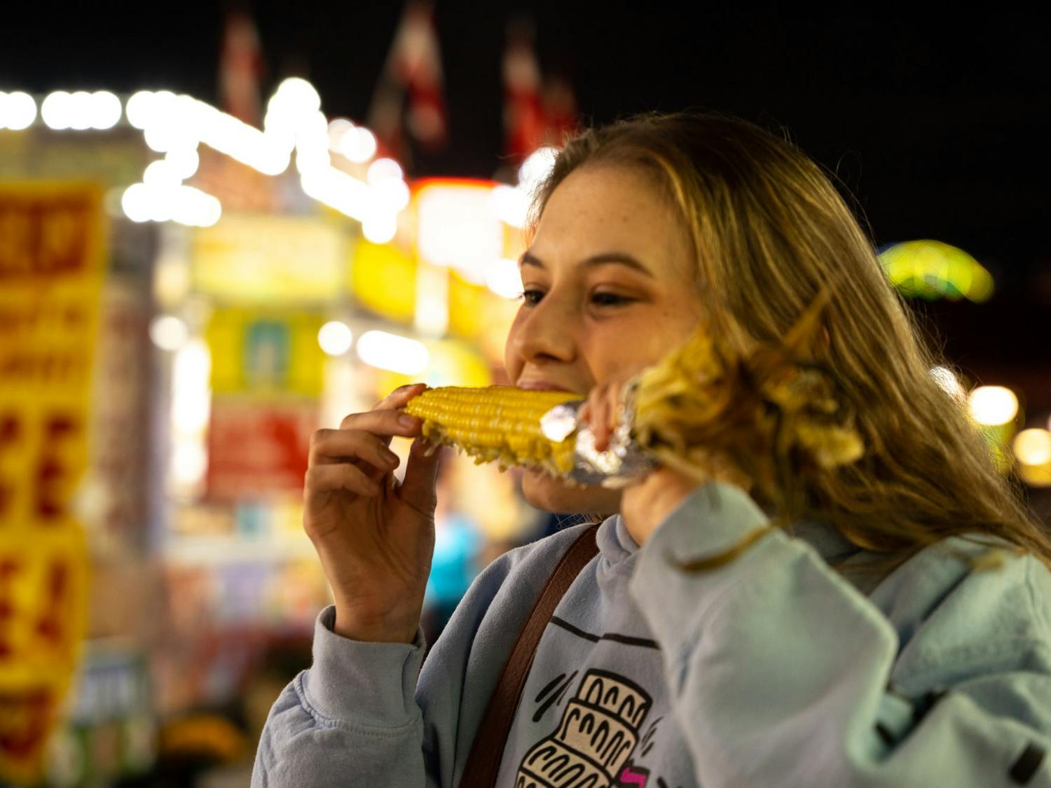 UNC student Laura Wilkerson enjoys corns from the North Carolina State fair.