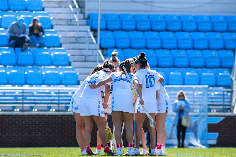 The UNC women’s lacrosse team huddles after a goal during the game against UF on Saturday, Feb. 18, 2023, at Dorrance Field. UNC beat UF 12-5.
