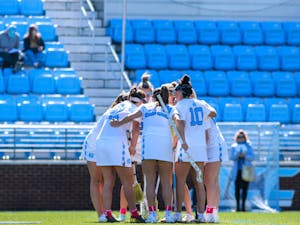 The UNC women’s lacrosse team huddles after a goal during the game against UF on Saturday, Feb. 18, 2023, at Dorrance Field. UNC beat UF 12-5.
