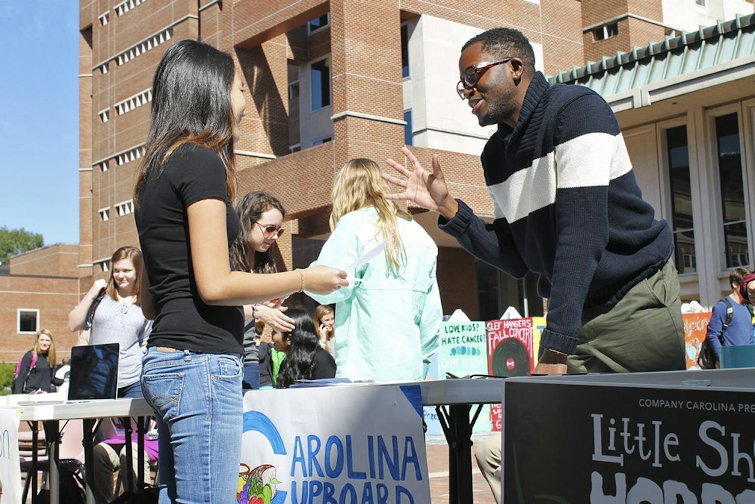 Roderick Gladney (right) helps recruit new members during Carolina Cupboard's opening week events in the Pit on Monday.