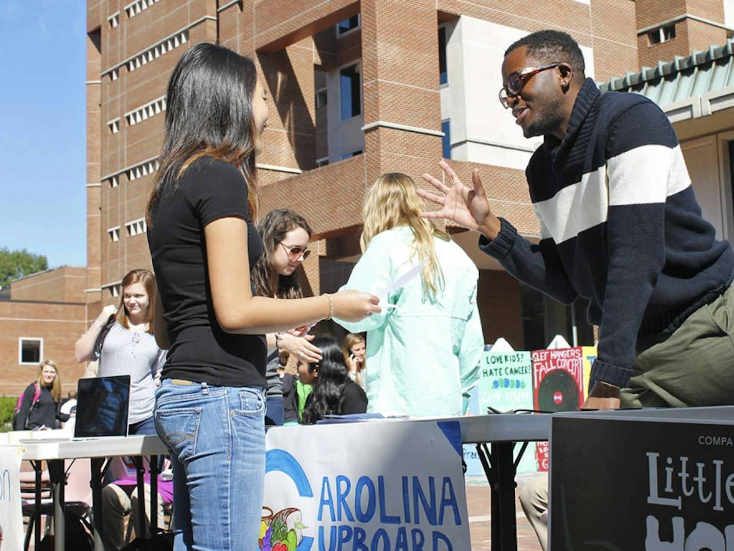 Roderick Gladney (right) helps recruit new members during Carolina Cupboard's opening week events in the Pit on Monday.