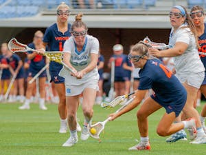 UNC first year midfielder Shannon Smith attempts to get the ball from a Virginia player at the game against Virginia on Sunday Apr. 18, 2021 at the Dorrance Field. UNC won 15-4.