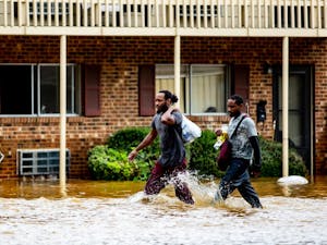 Kyrie and Michael Benton carry food and some of their waterlogged belongings through the grounds of Camelot Village apartments in Chapel Hill the morning of September 17, 2018. Chapel Hill had been seemingly spared the worst of Hurricane Florence but Sunday night into Monday morning saw a downpour of heavy rain that caused flash flooding around the Triangle. Camelot Village has seen flooding in the past but never to this degree, according to Kyrie and other residents of many years. "I lost everything in this flood," Kyrie said. Just as quickly as it flooded, the water began to recede late the same morning and early in the afternoon.