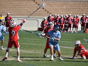 UNC junior midfielder Andy Matthews (12) battles for the ball against two St. John's defenders on March 3 at Kenan Stadium.