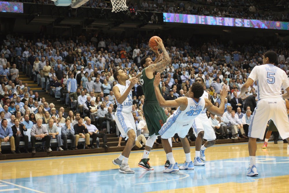 	<p>James Michael McAdoo draws the charge on Miami&#8217;s player.</p>