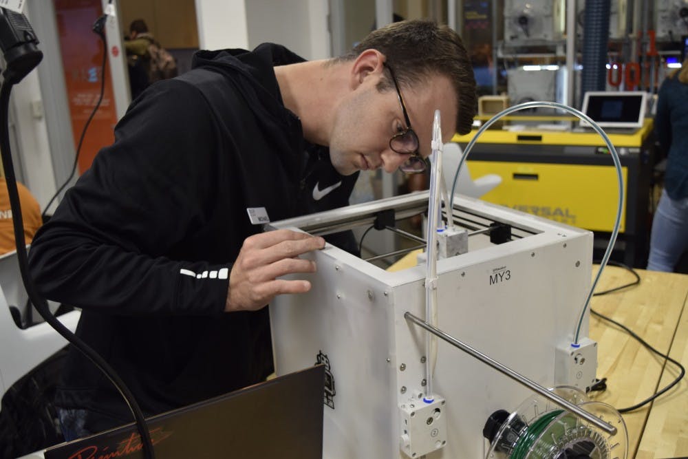 <p>Program Assistant Michael Aruch, a senior economics major, performs maintenance on a dysfunctional 3D printer in the Kenan Science Library Makerspace Wednesday, Nov. 14, 2018.&nbsp;</p>