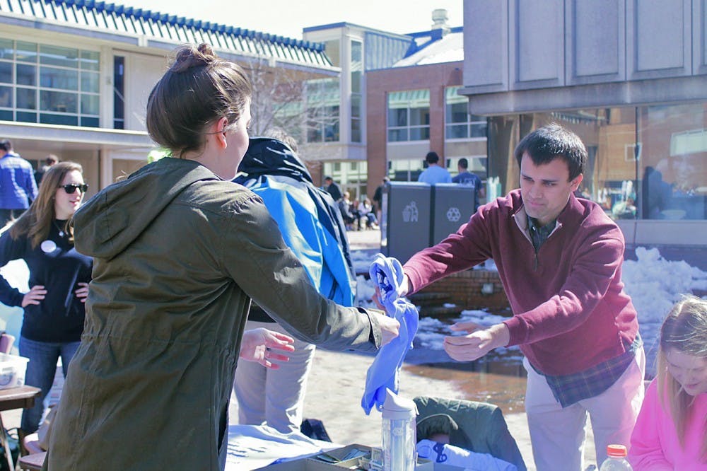 Chris Welch, public policy major, helps the Carolina Athletic association kickstart Beat Duke Week by selling Beat Duke shirts in the pit on Monday.
