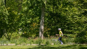 A woman jogs down a trail at the Coker Arboretum on Tuesday, April 18, 2023.