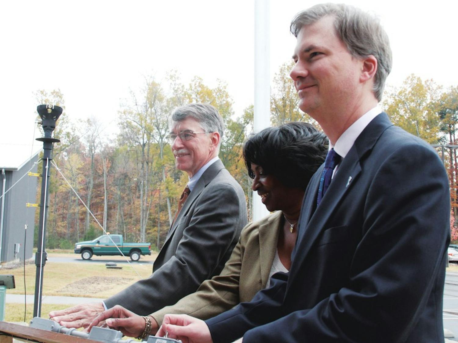Rep. Joe Hackney, Valerie Foushee and Holden Thorp prepare to light a symbolic flare Monday marking the start of a joint project between UNC and Orange County to convert methane gas into electricity.