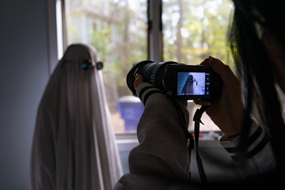 DTH Photo Illustration. Many students have been taking part in various TikTok trends, such as ghost photoshoots or wearing wigs.