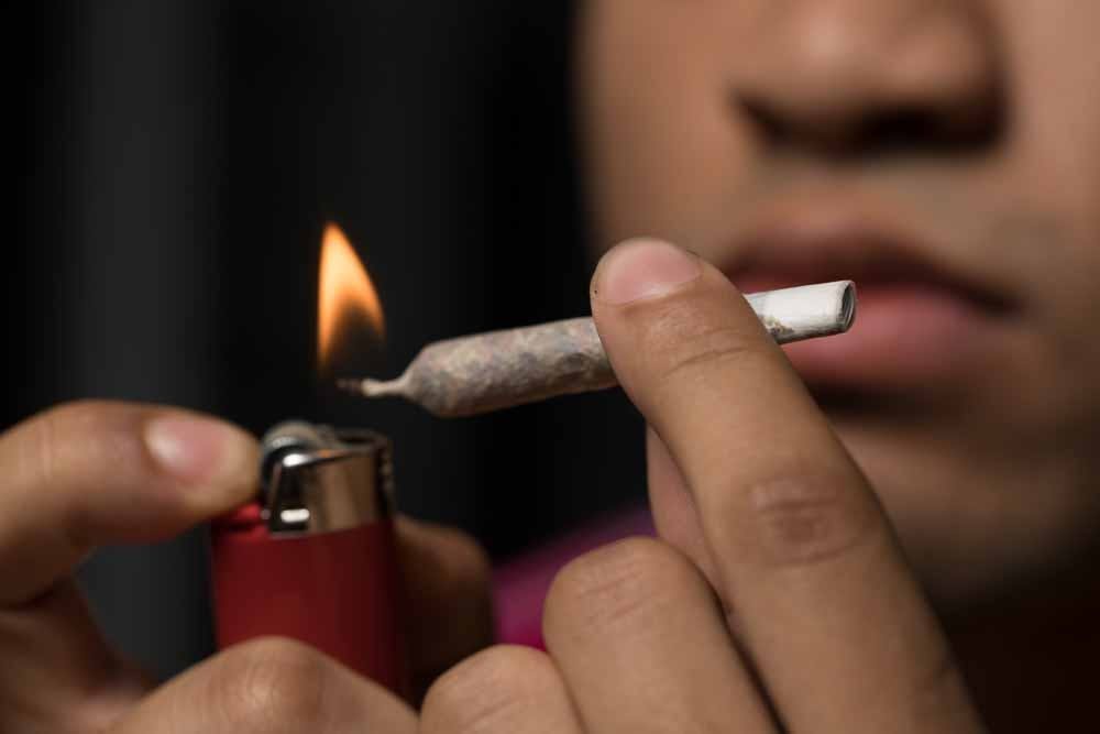 <p>A UNC student lights a joint filled with marijuana as part of a photo illustration. U.S. Sen. Thom Tillis, R-NC, co-sponsored a bill that would legalize medical marijuana.&nbsp;</p>