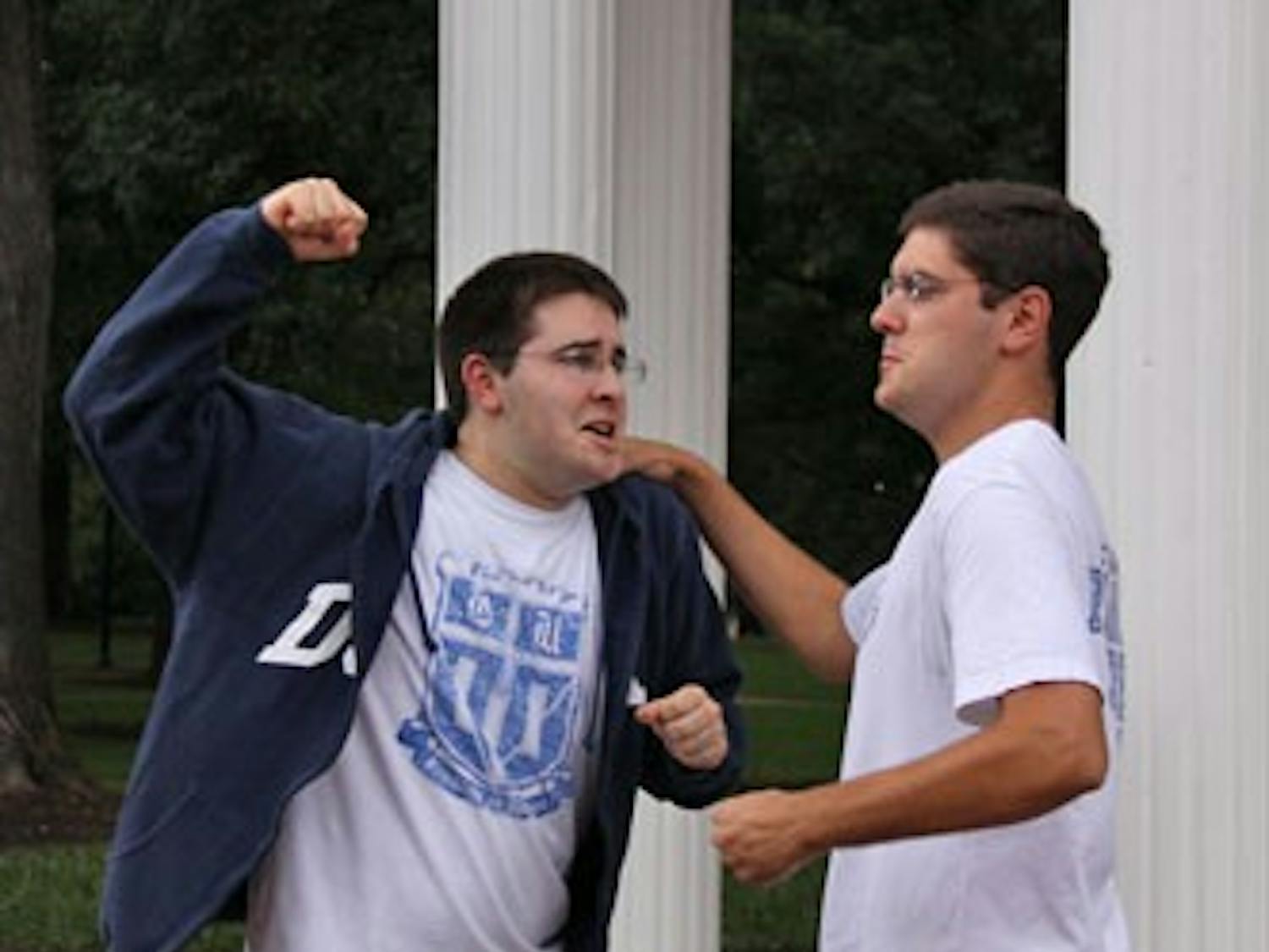 Alex Klein, left, and Mike Santangelo, long-time best friends, illustrate their allegiances to their opposing alma maters.