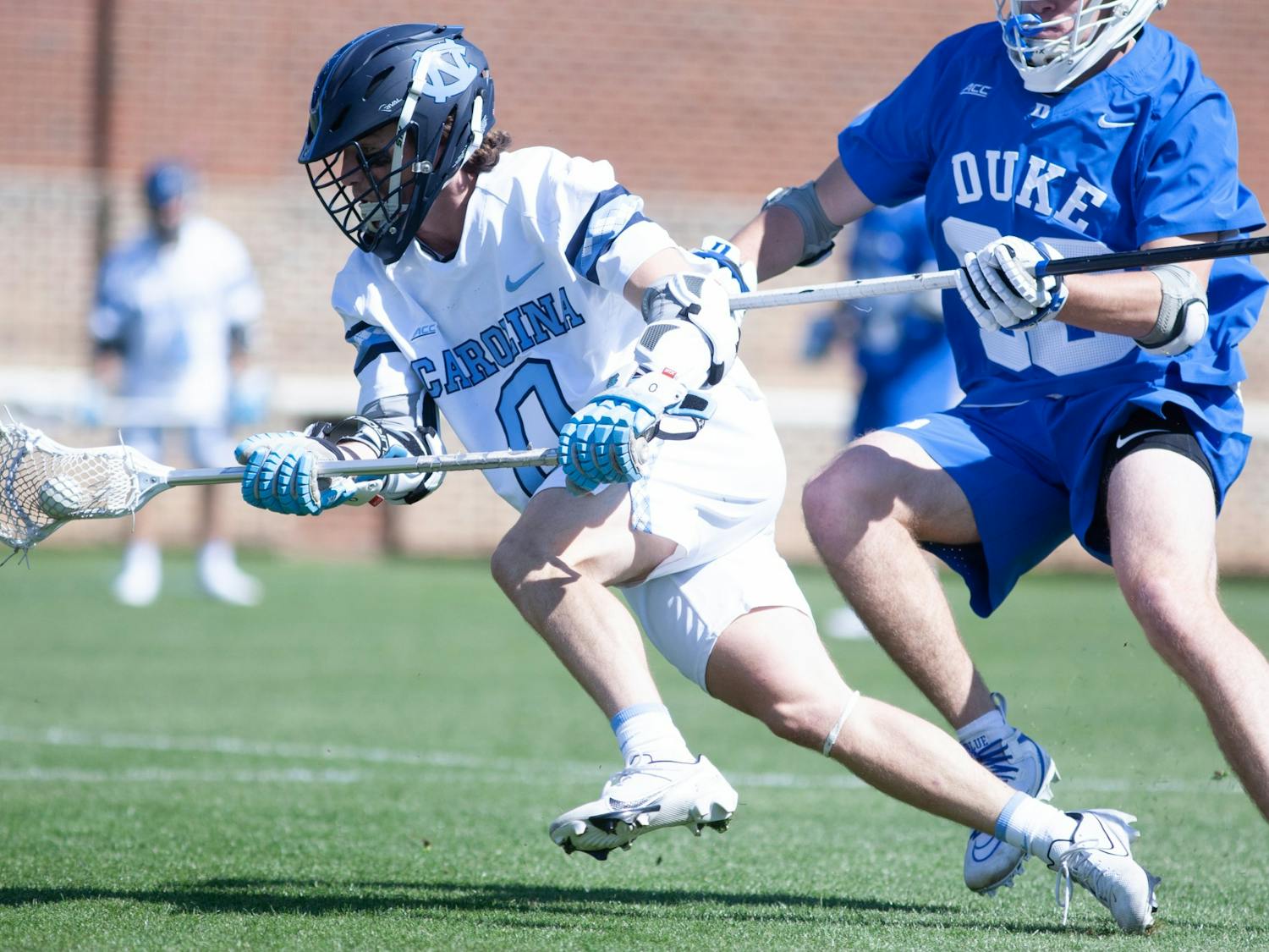 UNC junior attackman Lance Tillman (0) drives past a defender during a home game against Duke at Dorrance Field on Saturday Apr. 2, 2022.