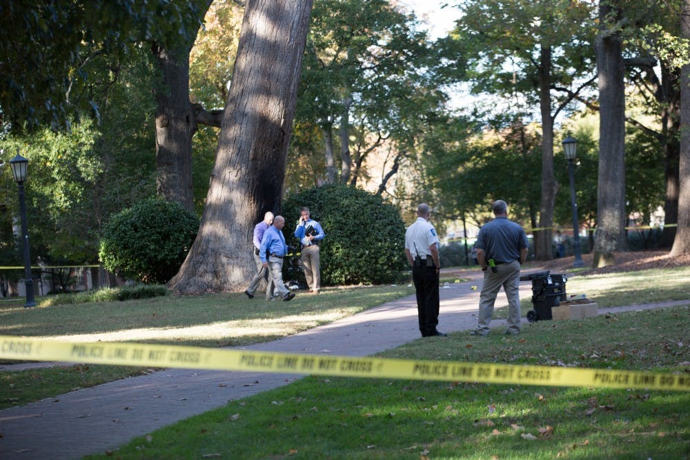<p>Police investigate an explosion at the Davie Poplar tree in McCorkle Place on Thursday afternoon.</p>