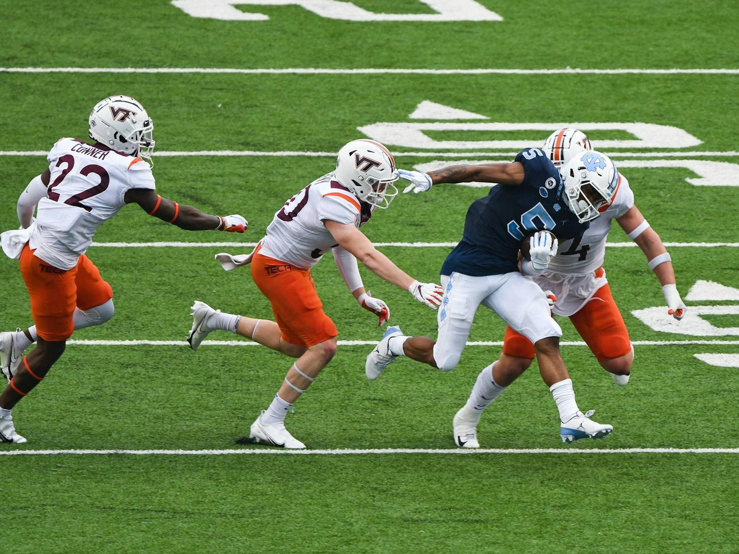 UNC senior wide reciever Dazz Newsome (5) attempts to run past members of Virginia Tech's defensive line during a game in Kenan Memorial Stadium on Saturday, Oct. 10, 2020. UNC beat Virginia Tech 56-45.
