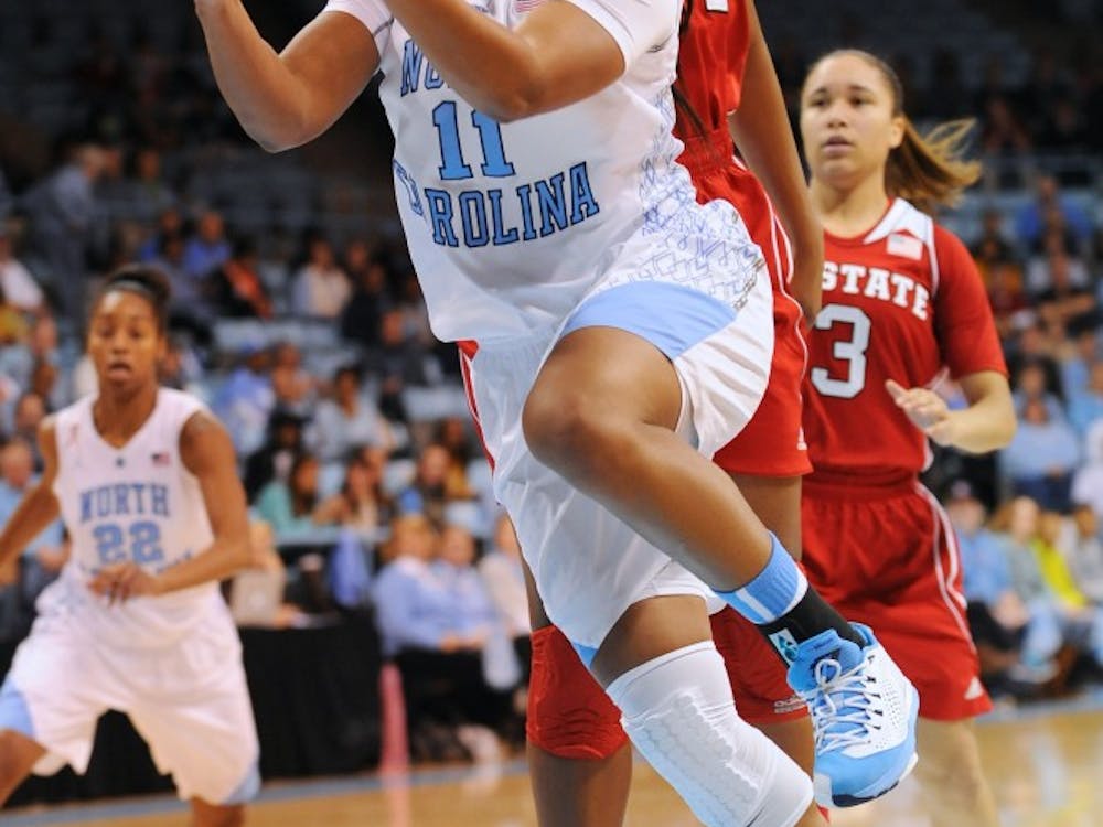 UNC guard Brittany Rountree (11) takes a layup as NC State forward Kody Burke (44) defends.
