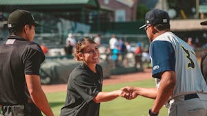 Junior UNC softball player Kayla Baptista shakes hands with the coach of an opposing team before a Down East Wood Ducks game, the low A affiliate of the Texas Rangers. Baptista spent the summer working as a Player Development Coach with the Rangers. Photo courtesy of Baptista.
