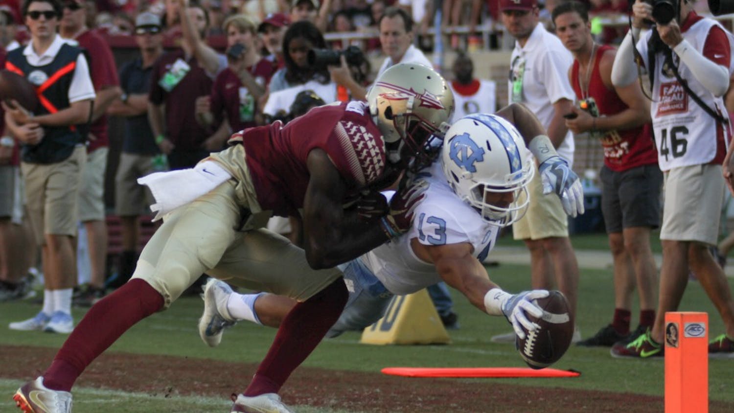 Mack Hollins (13) makes a diving play while being defended by an FSU player to score a touchdown.