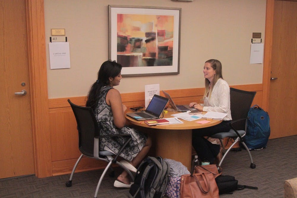 <p>Alexis Barron (right) and Sri Sure (left) manage interviews at the University Career Services Center on the 4th floor of Hanes hall on Wednesday, Sept. 26, 2018.</p>