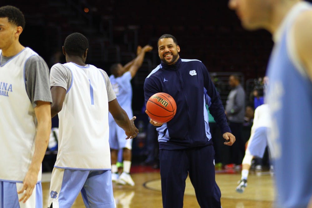 Sean May hands the ball back to Theo Pinson (1).