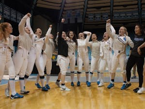 The North Carolina women's fencing team celebrates its 2018 ACC team title, the first in school history, on Feb. 24 in Carmichael Arena.