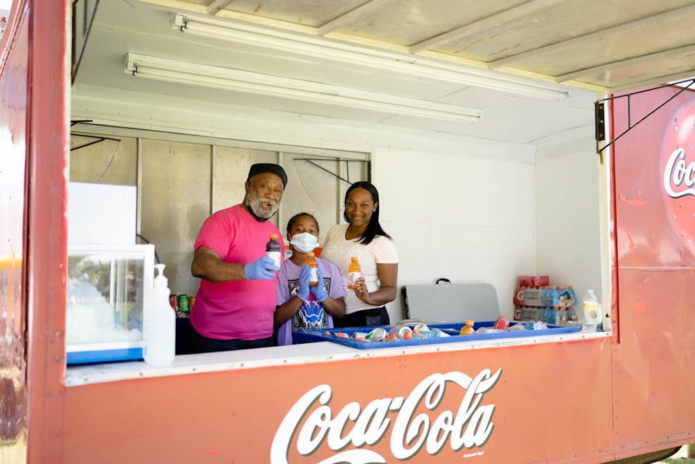 Reverend Robert Cambell, Robin McClain and Noahh McClain provide cold beverages in front of Hargraves Community Center at the Chapel Hill-Carrboro Juneteenth Celebration on Sunday, June 19, 2022.