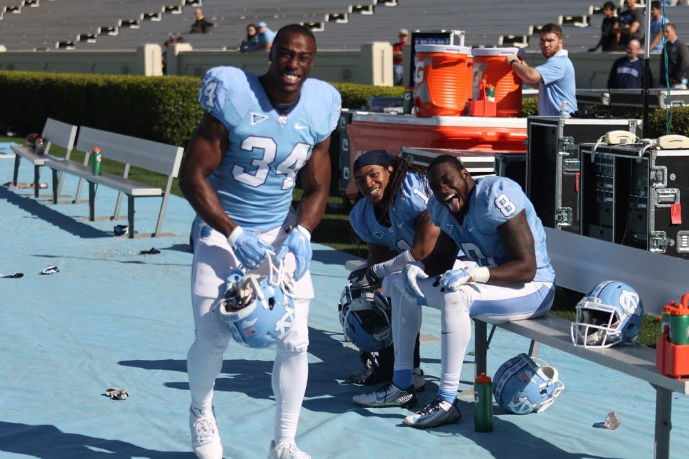 Running backs Elijah Hood (34), TJ Logan (8) and tailback Khris Francis (1) share a laugh on the sideline during the North Carolina football team's Spring Game on Saturday.